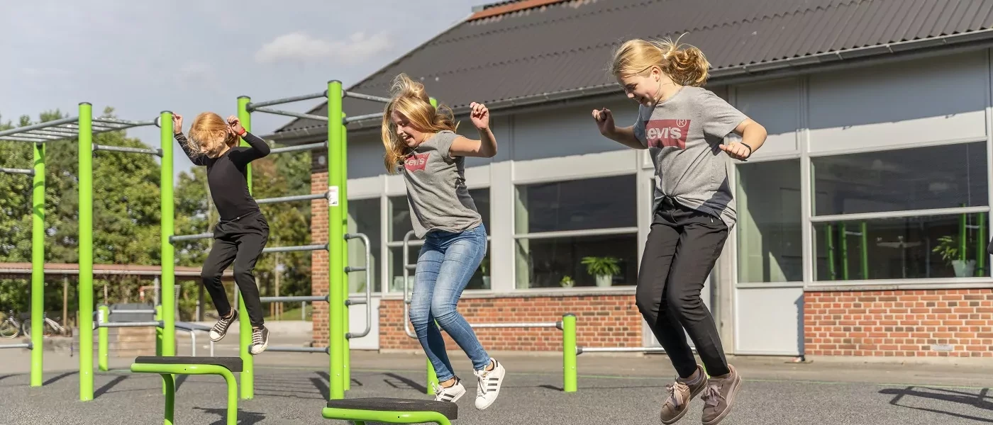 girls jumping on jumpers on a playground