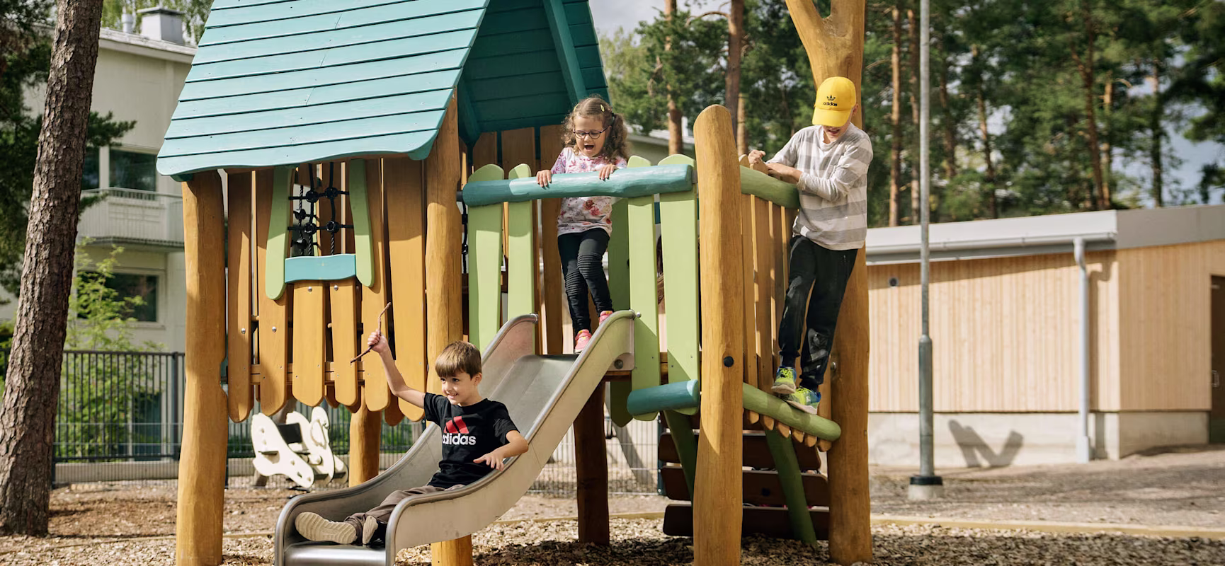 children playing on nature play equipment at their kindergarten