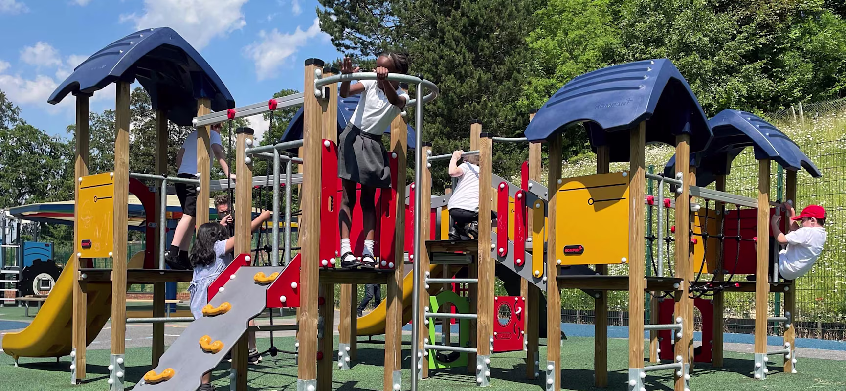 Children are playing on a playground structure in a school yard