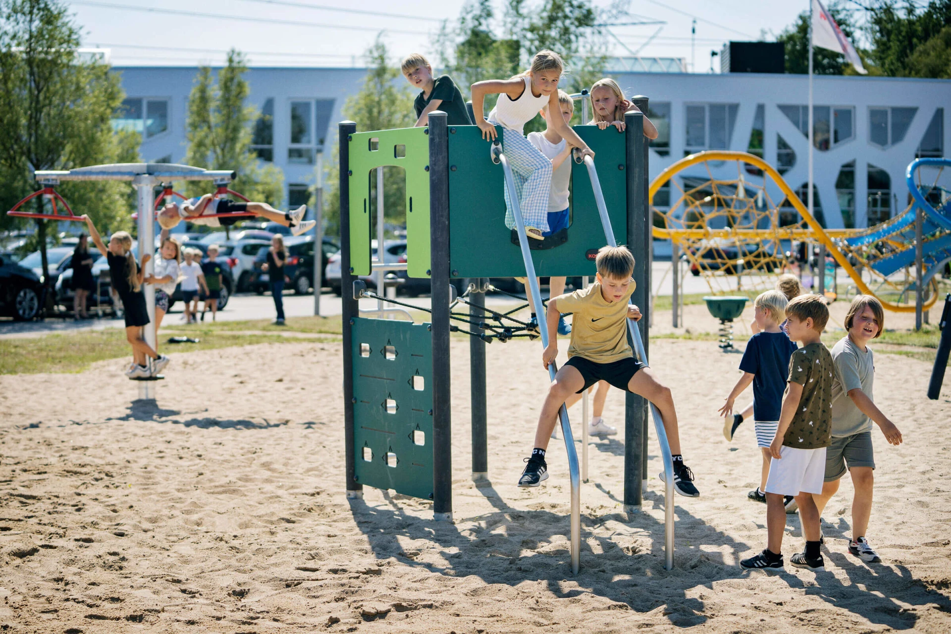 lapset kiipeilemässä kiipeilyleikkivälineellä koulun pihalla