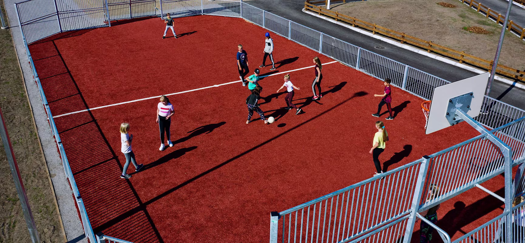 Children playing soccer at a multi sport games area at Kuopio school