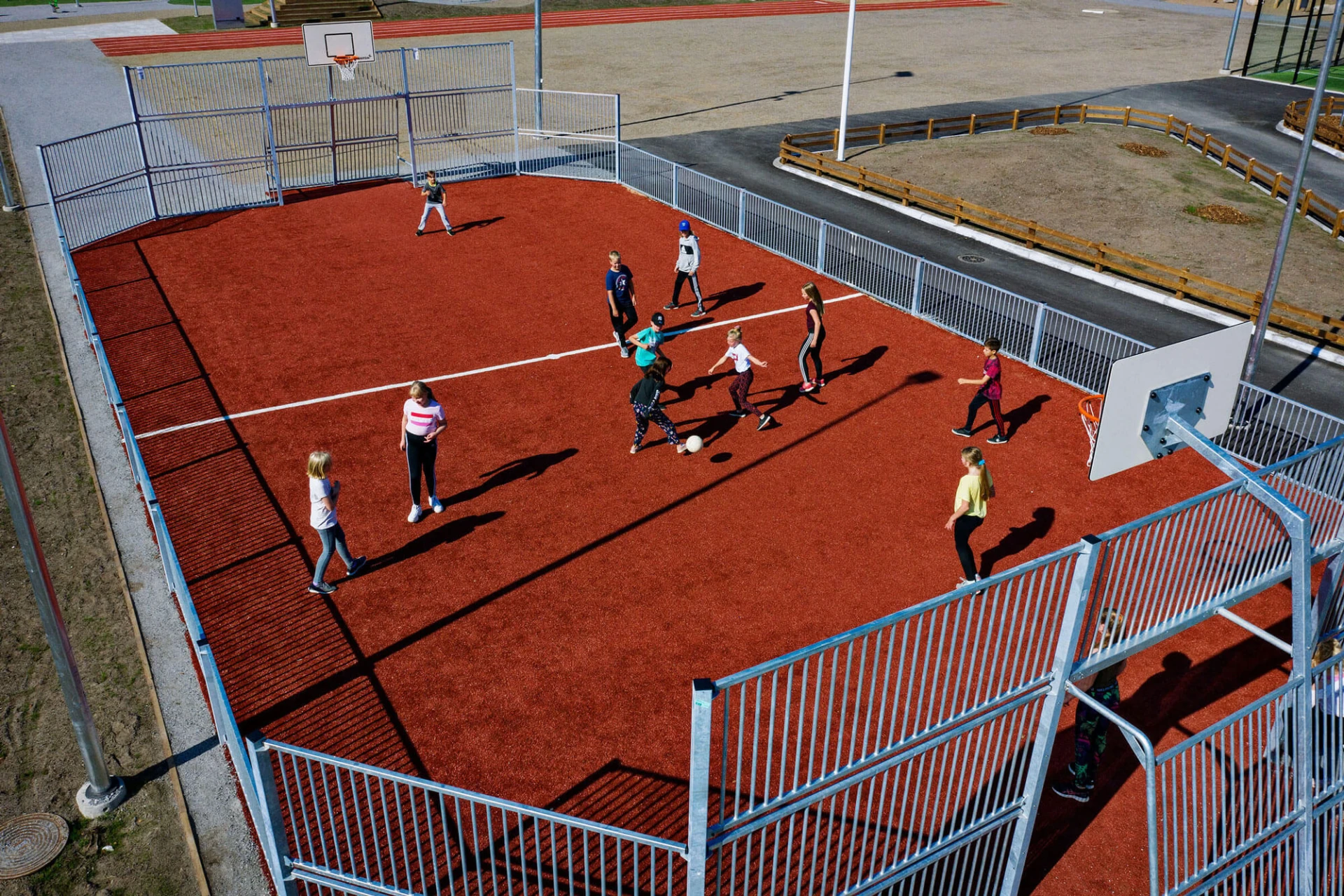 Children playing soccer at a multi sport games area at Kuopio school