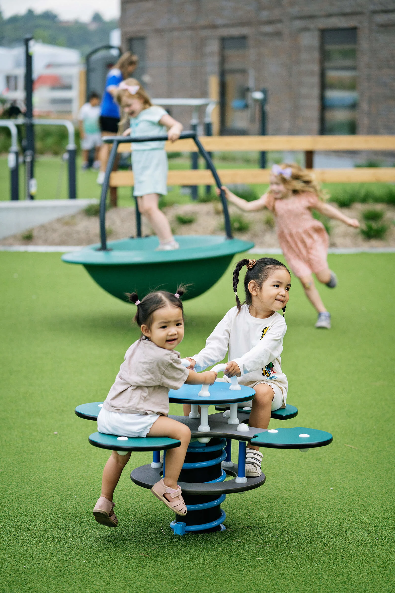 Toddlers playing on daisy springer playground equipment