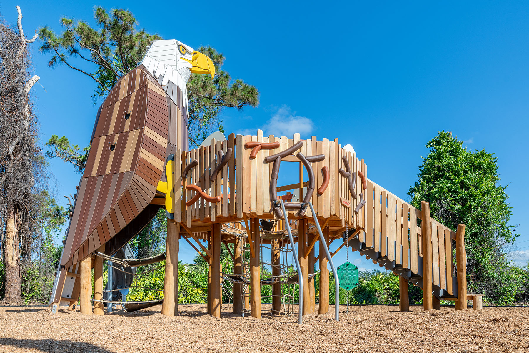 A custom wooden play structure, featuring a climbable robinia eagle, at Cedar Point Playground in Englewood, Florida