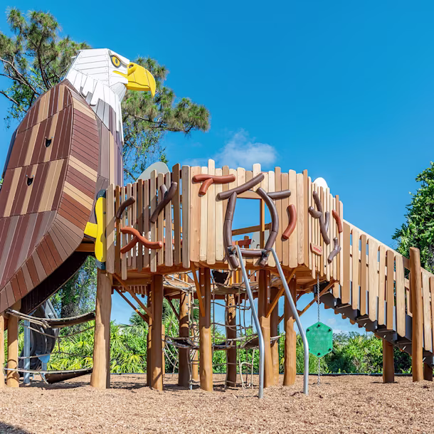 A custom wooden play structure, featuring a climbable robinia eagle, at Cedar Point Playground in Englewood, Florida