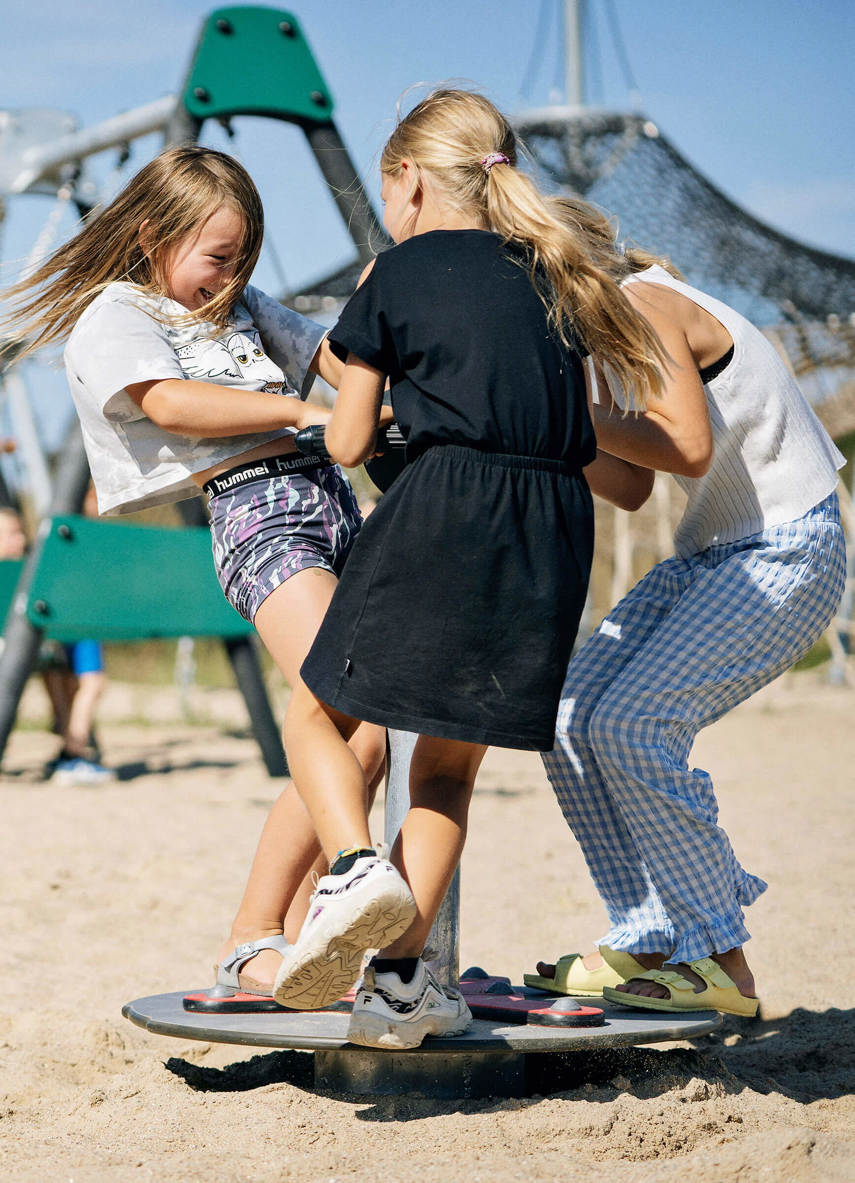 Girls playing, spinning on a school yard playground
