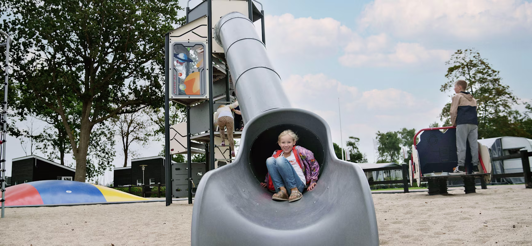 Girl sliding down from a space theme playground tower at CampOne Assens