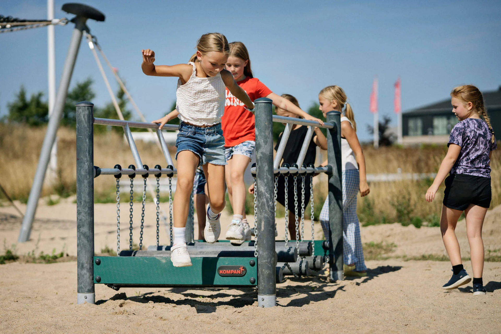 Mädchen balancieren auf der Wackelbrücke auf einem dänischen Spielplatz