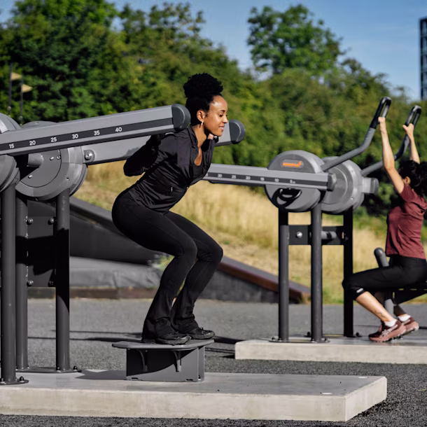 Man and woman working out on an outdoor gym