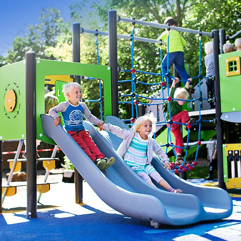 förskolebarn som glider på MOMENTS lekplatssystem i en park