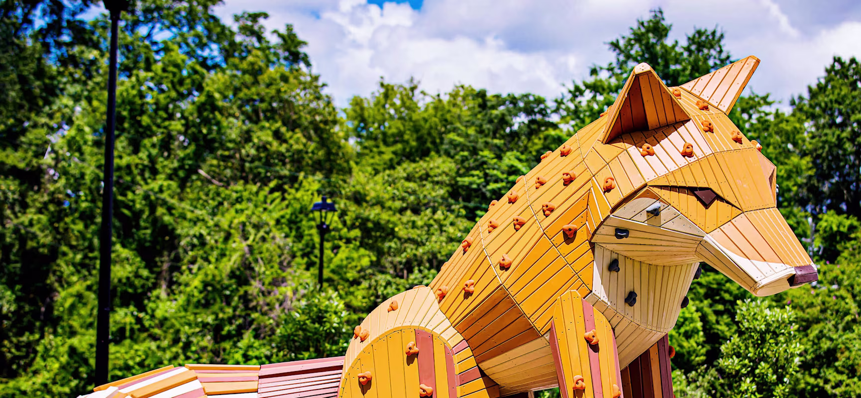 Wooden play sculpture at Amazing Grace Park looking like a fox