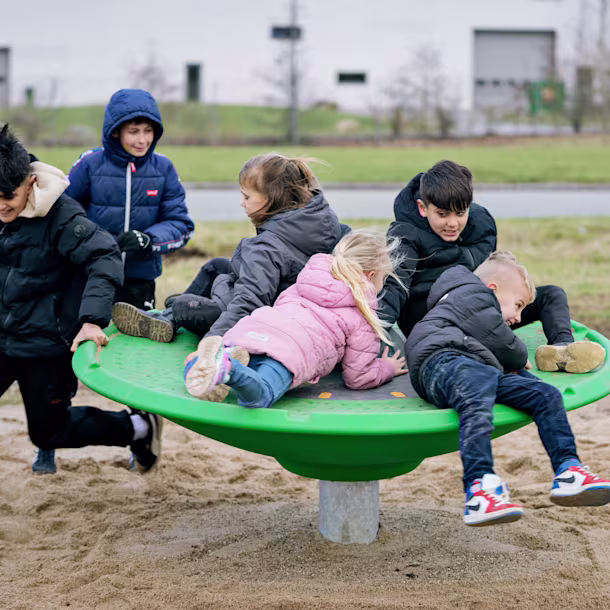 Children playing on the KOMPAN Spinner Disc