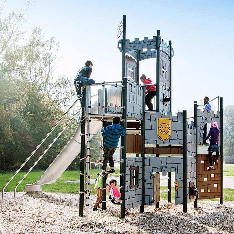 Kinder spielen auf einer Spielplatz Burganlage von KOMPAN in einem Park