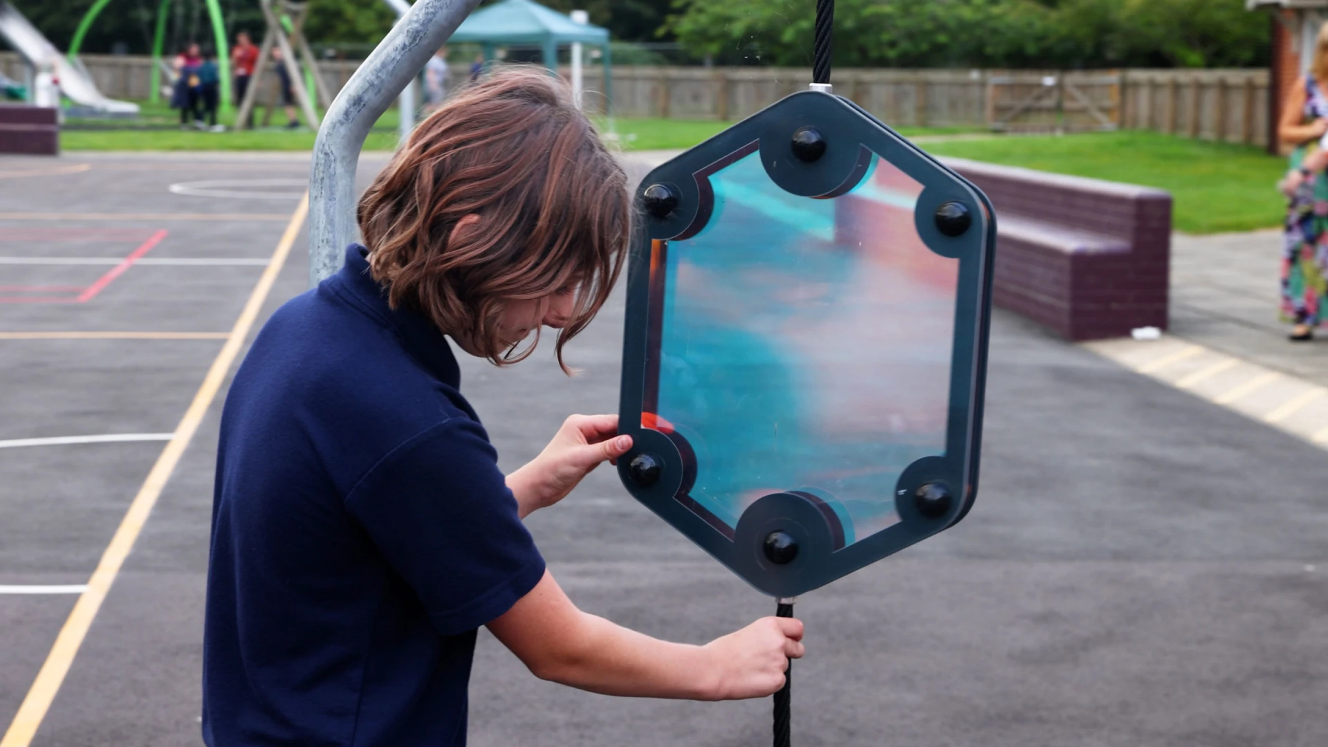 Garçon jouant avec des panneaux de jeux sensoriels sur une aire de jeux