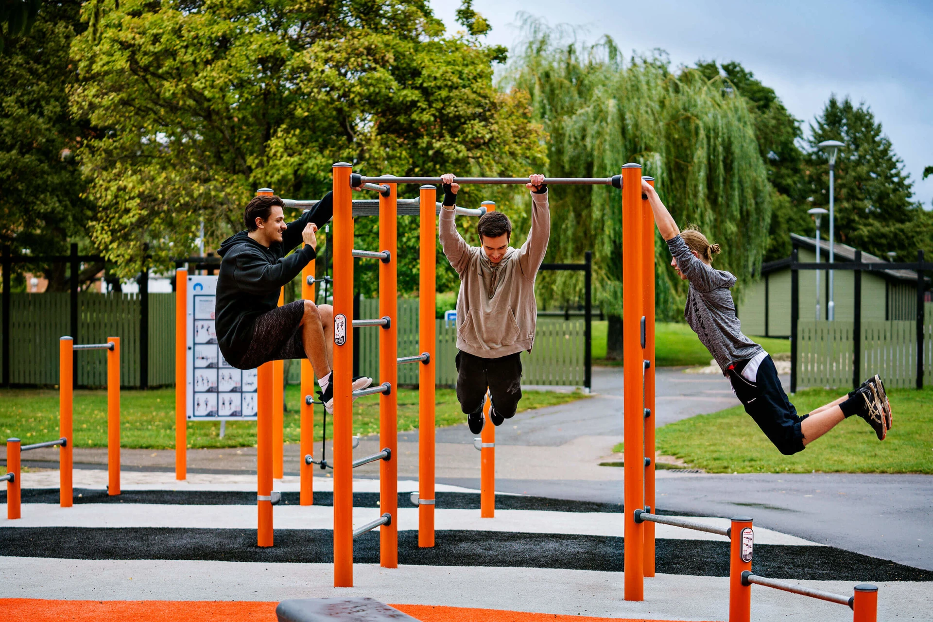 tre unga män tränar med calisthenics utrustning i street workout gym