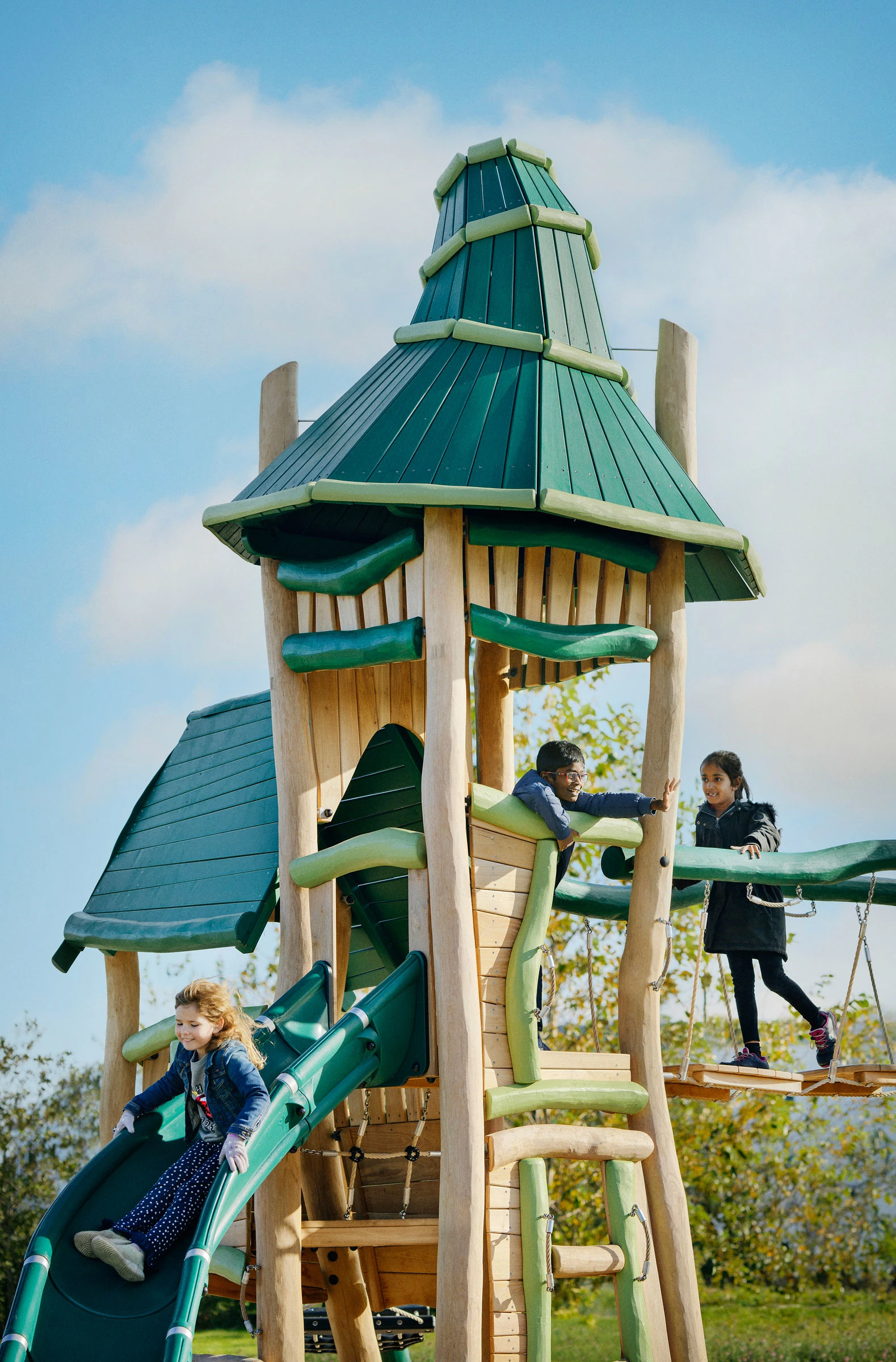A group of kids playing on a giant wooden lion playground play set