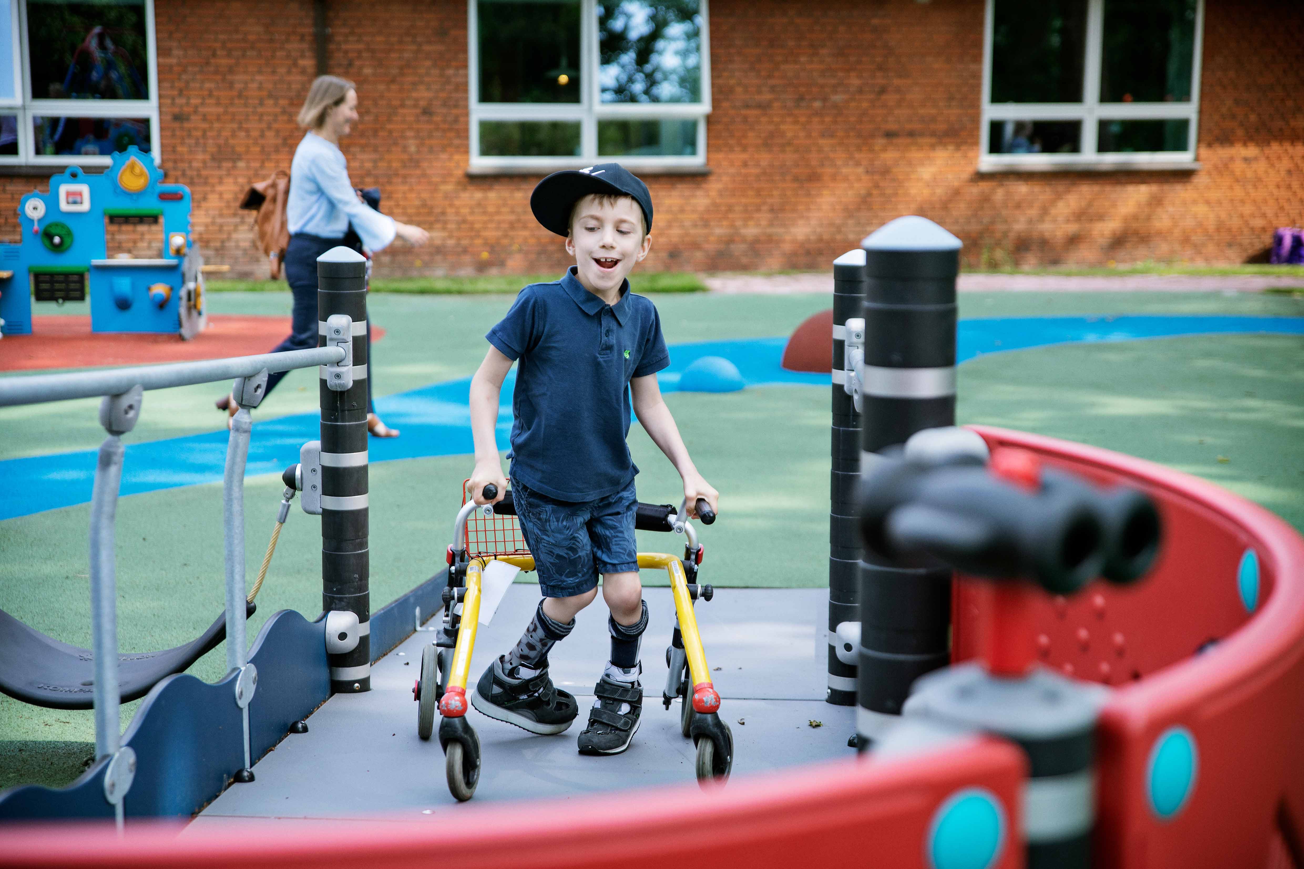 a young boy accessing playground via a ramp structure.