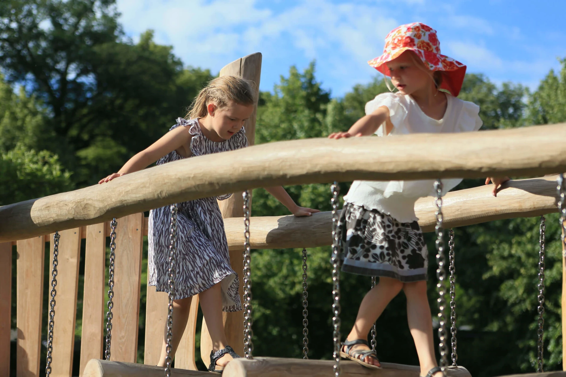 children balancing on a natural playground obstacle at copenhagen zoo