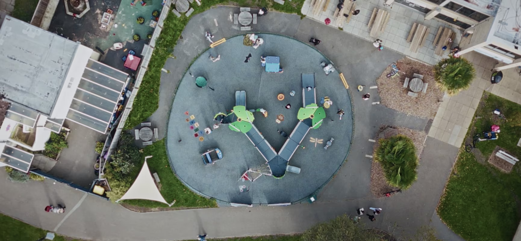 Boy in red clothes playing on a green playground structure