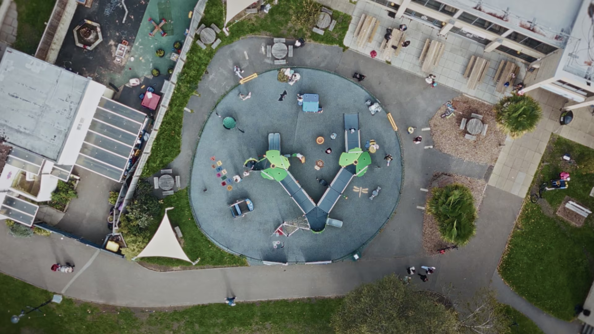 Boy in red clothes playing on a green playground structure