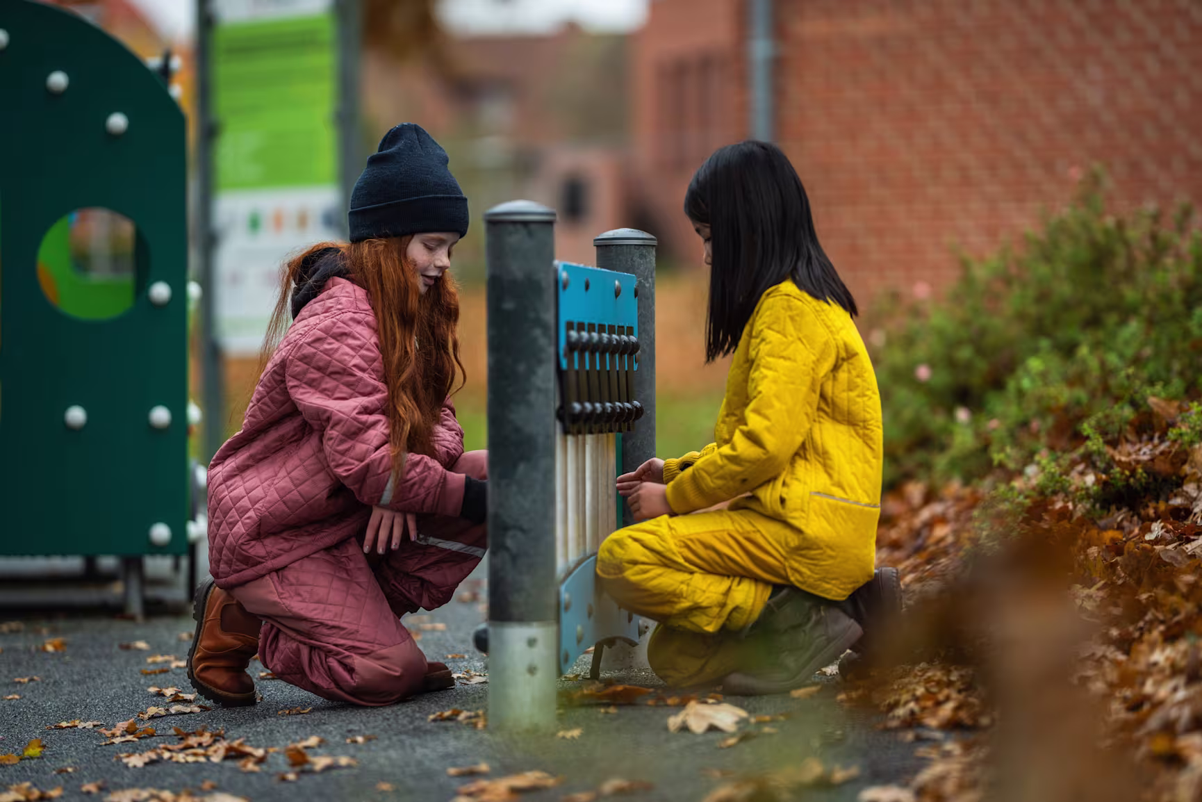 two girls playing on a musical playground panel