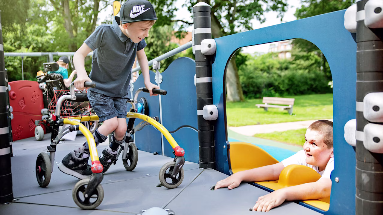 Niños jugando en un parque infantil ADA accesible e inclusivo