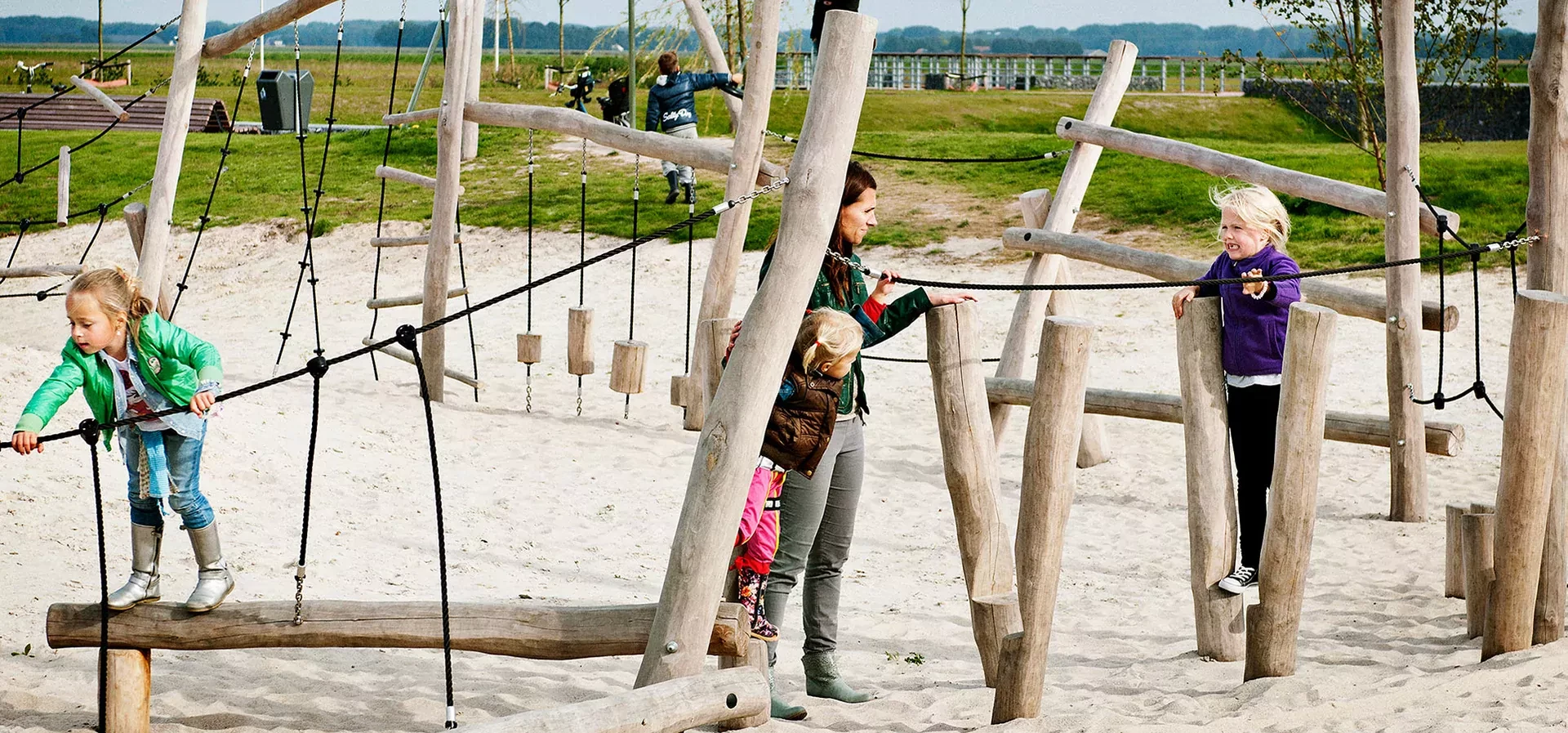 Children playing on a wooden climbing trail obstacle course