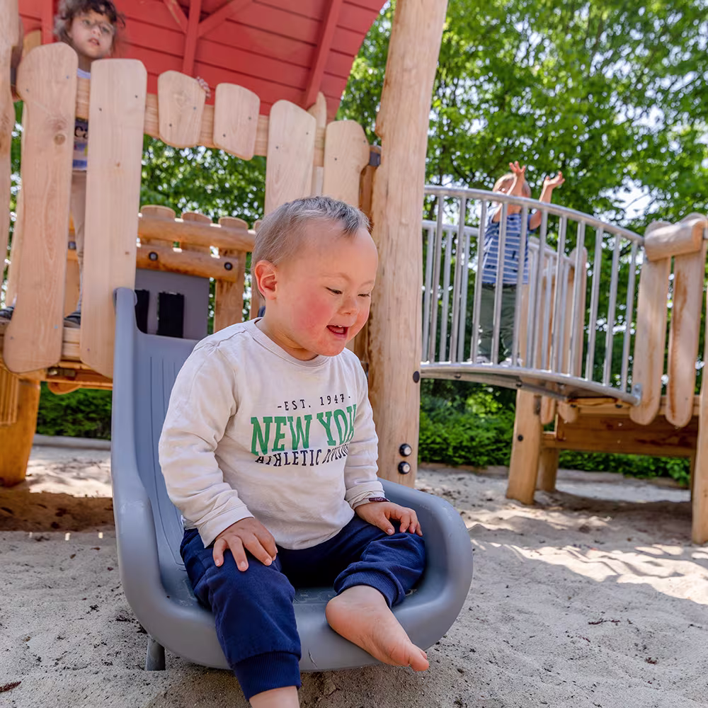 Mädchen im Rollstuhl spielt an sensorischen Spielelementen