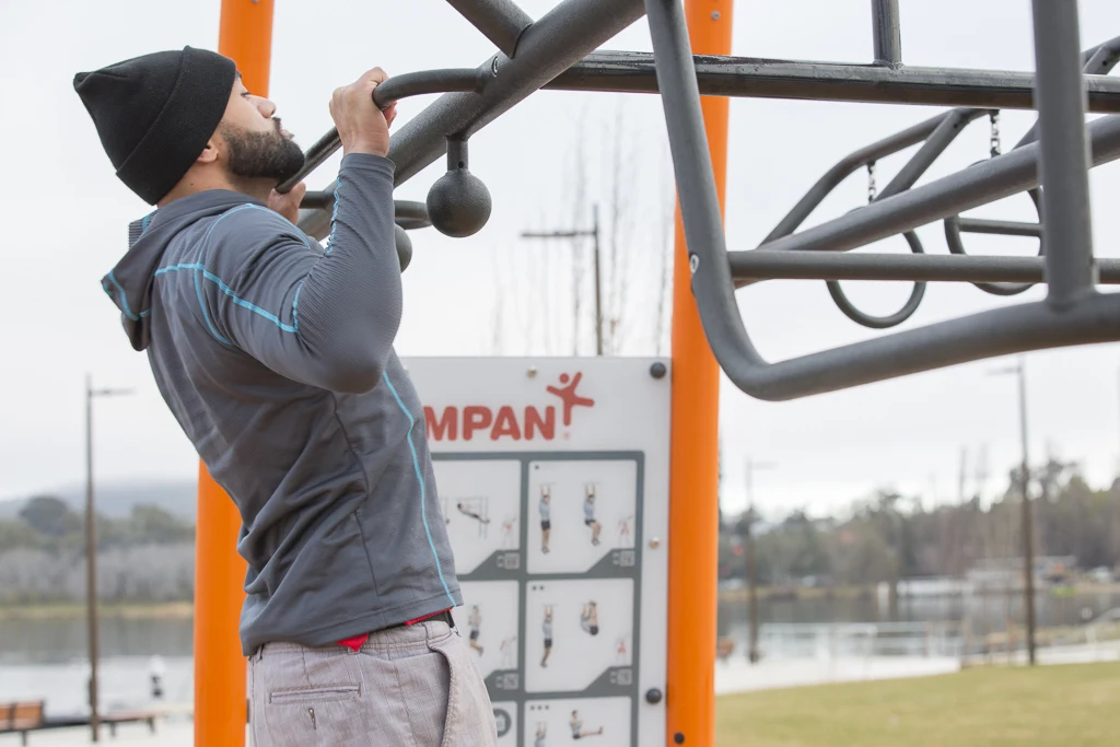 Man doing pull-ups at Henry Rolland Park outdoor gym