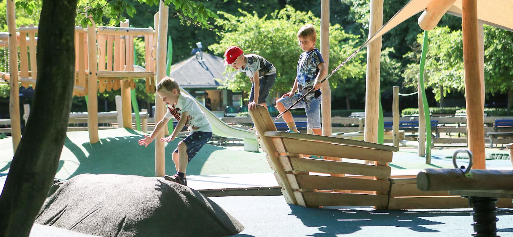 Boy jumping from a wooden boat on playground in Copenhagen Zoo