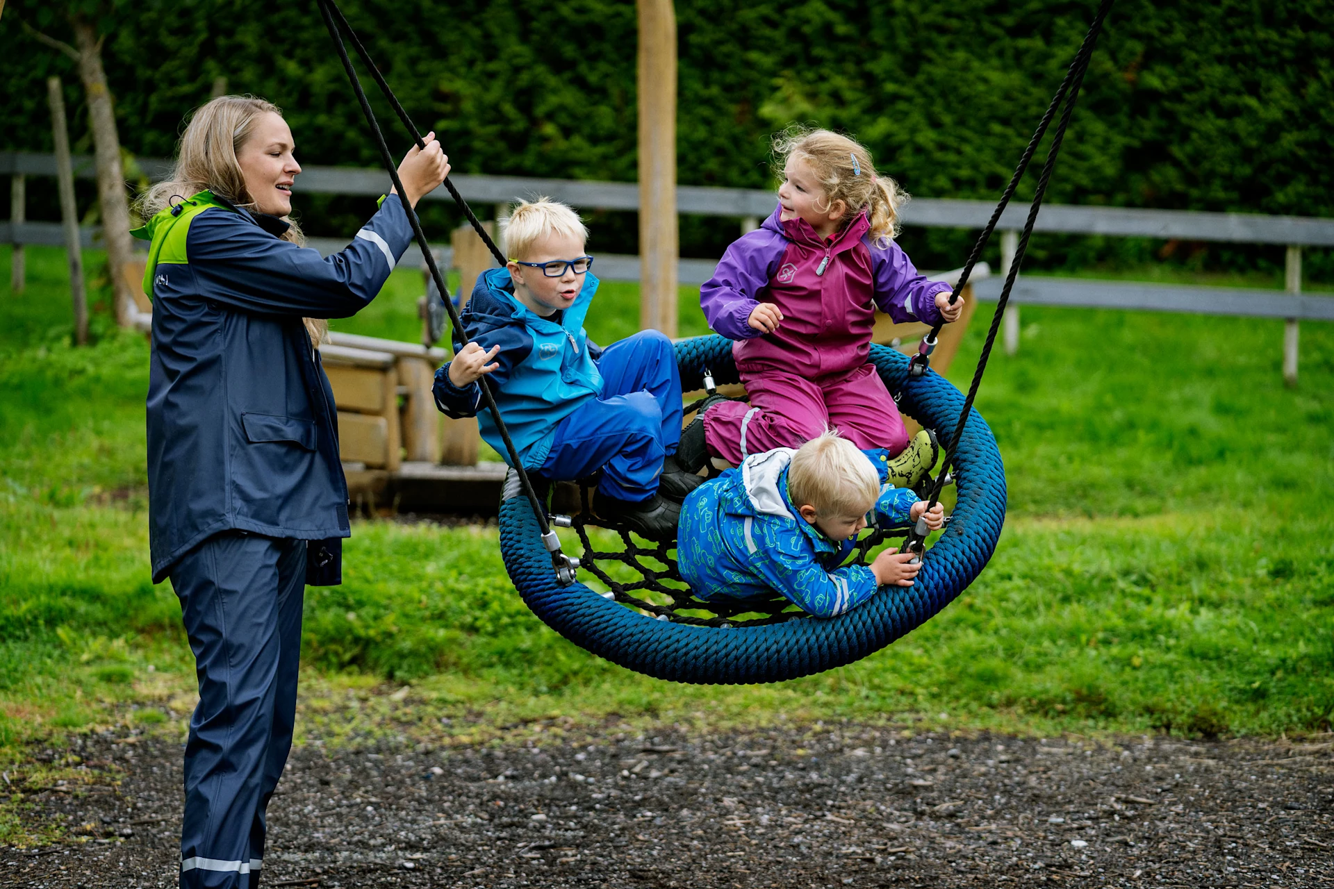 Children playing on kindergarten playground equipment in wood