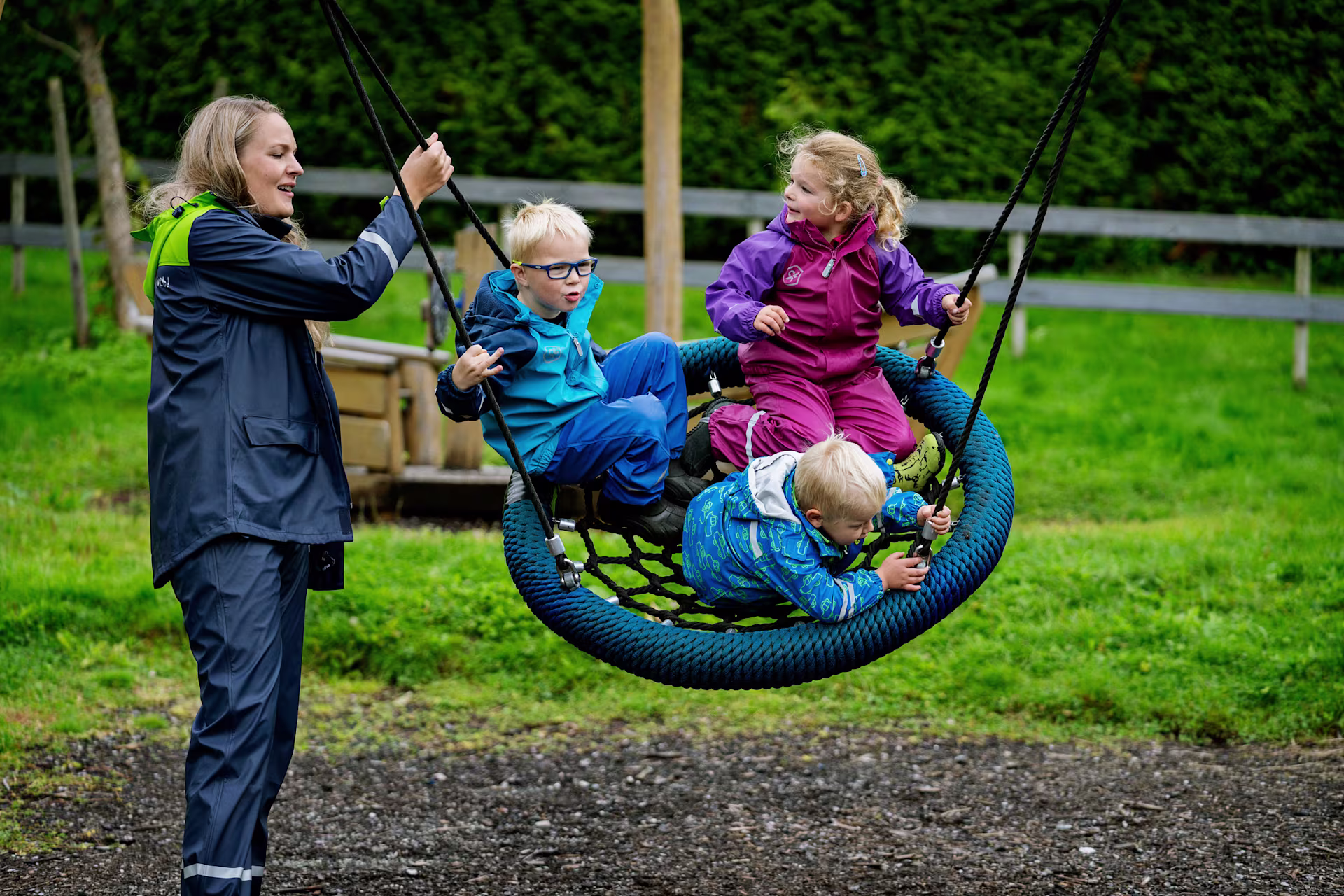 Children playing on kindergarten playground equipment in wood