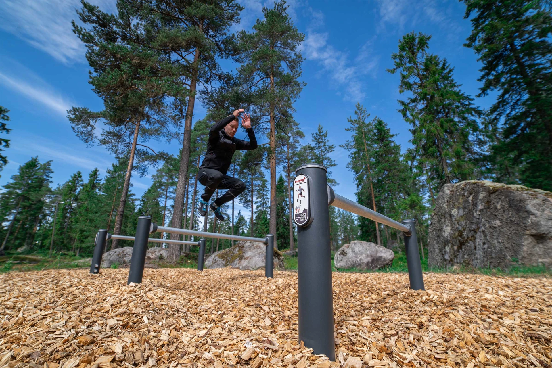 Man jumping over hurdles on an obstacle course in the woods