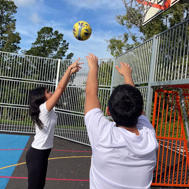 tweens playing basket on a multi court at their schools' playground