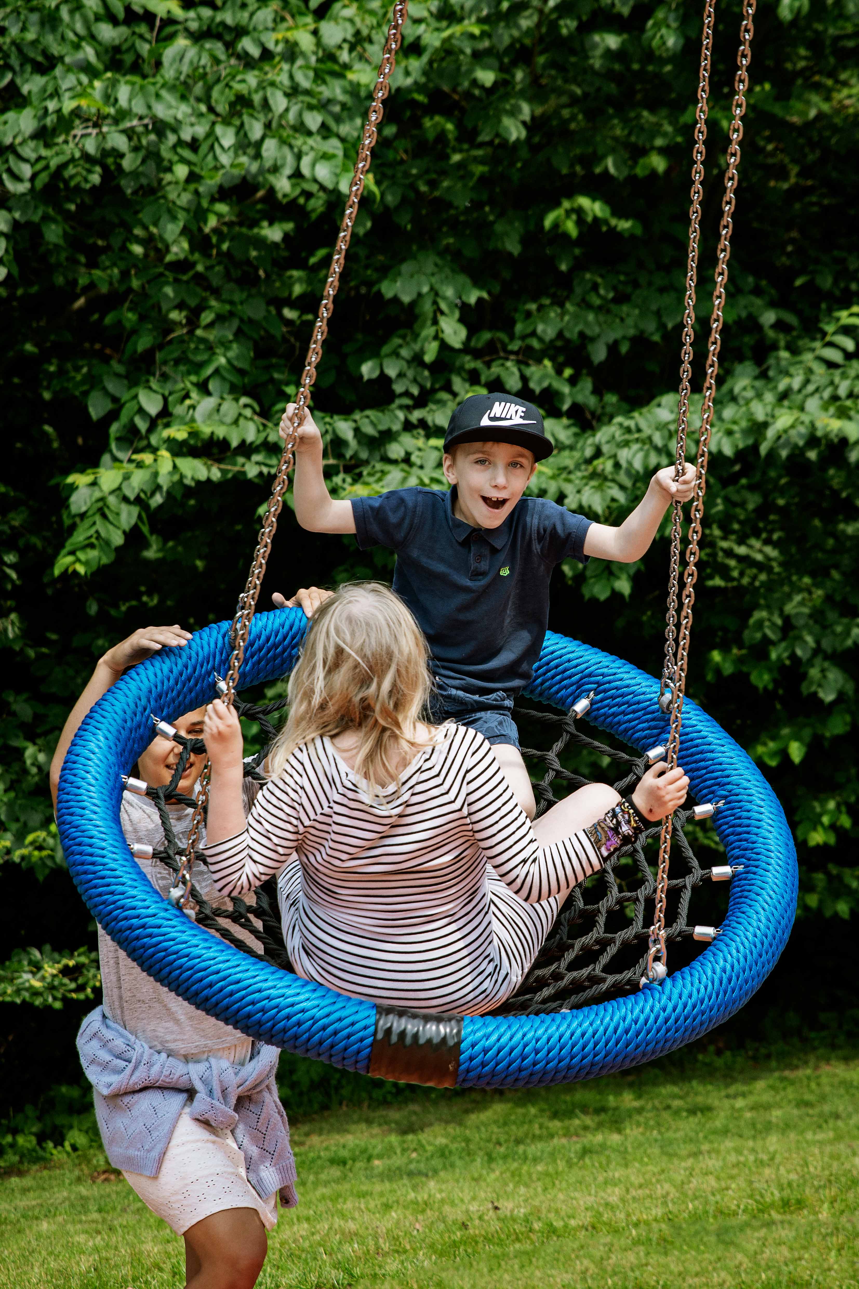 a boy and a girl playing on a inclusive swing