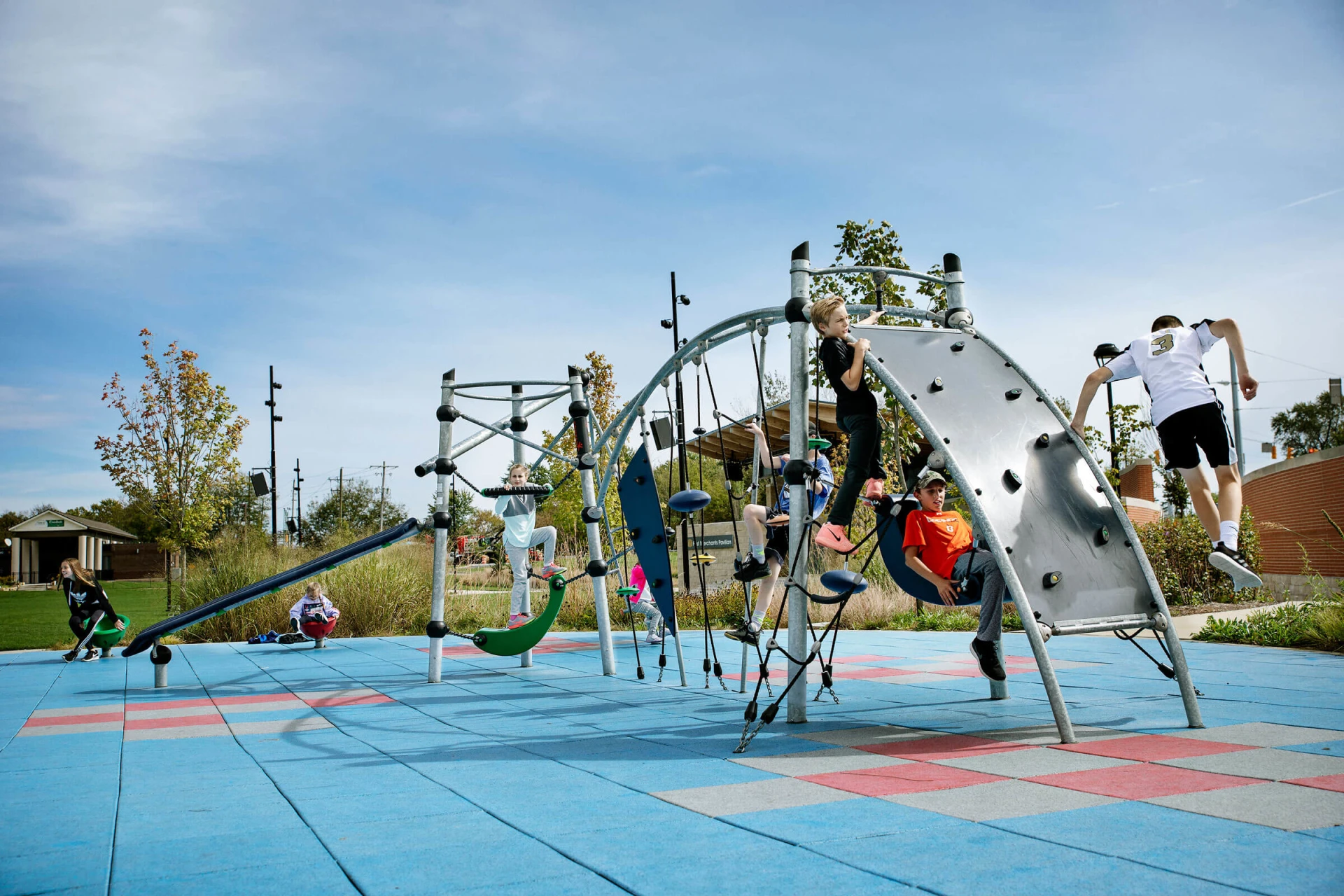 Teens playing on play system for school-agers at Federal Hill Commons Park