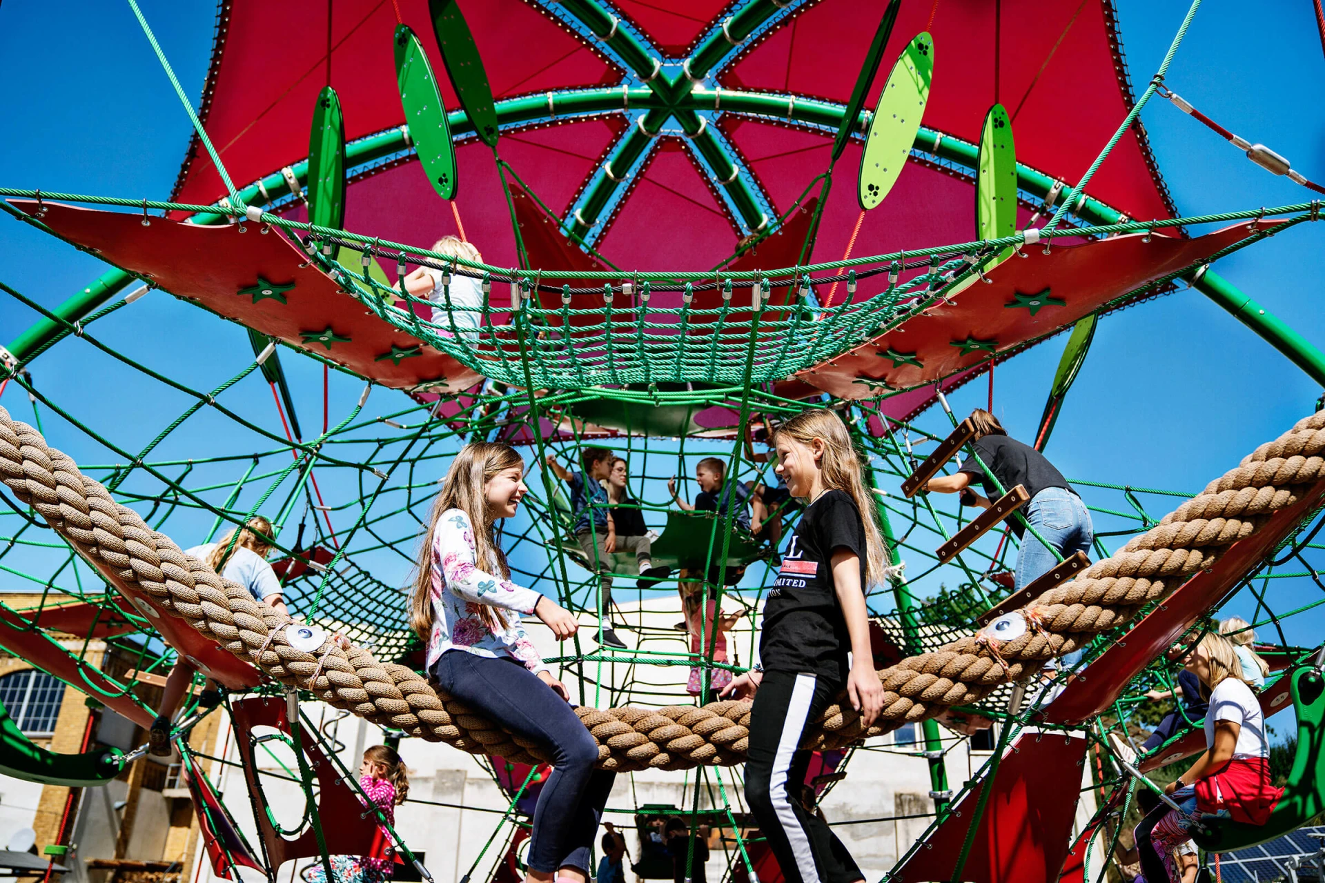 A group of children playing on a rope playground structure