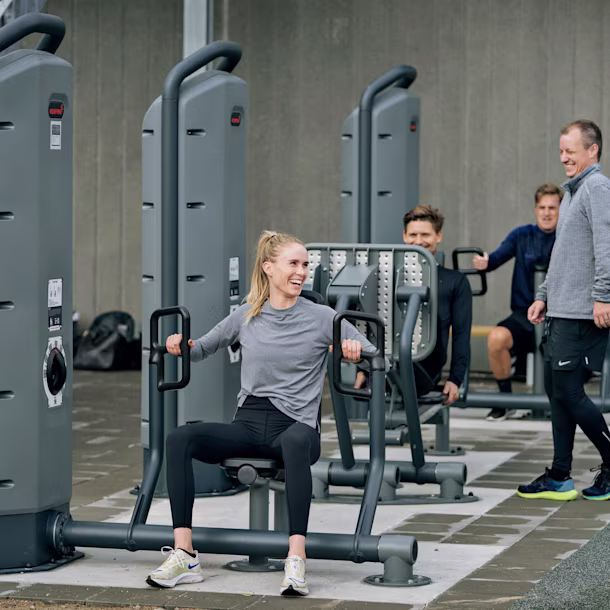 Persone in un parco che usano le macchine per l'allenamento della forza
