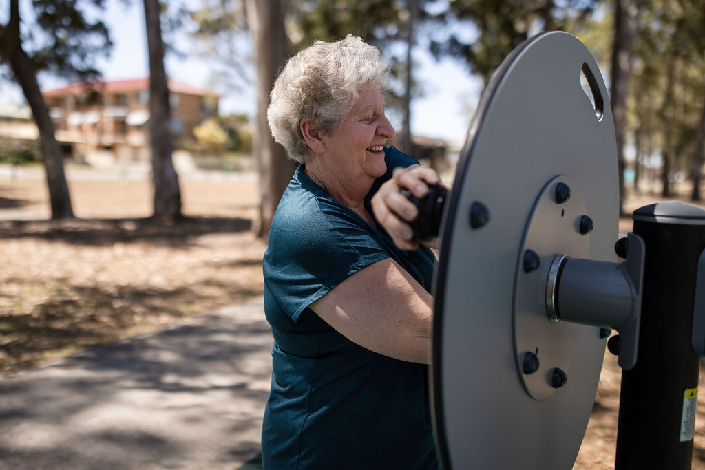 people working out on outdoor fitness equipment