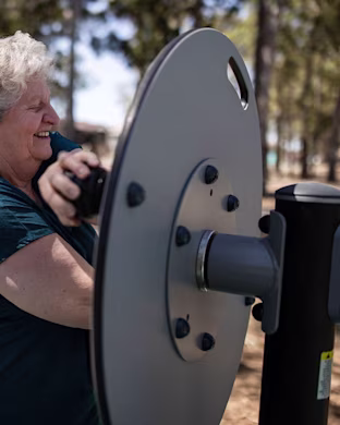 people working out on outdoor fitness equipment