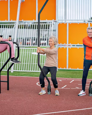 people working out on outdoor fitness equipment