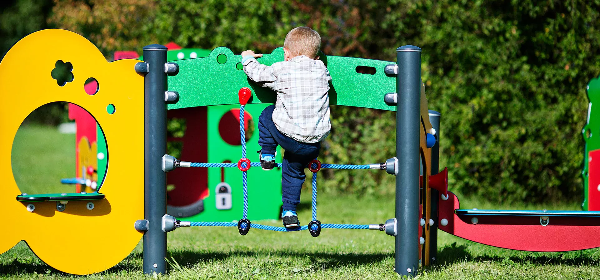 hero of a boy climbing on a colourful toddler play system