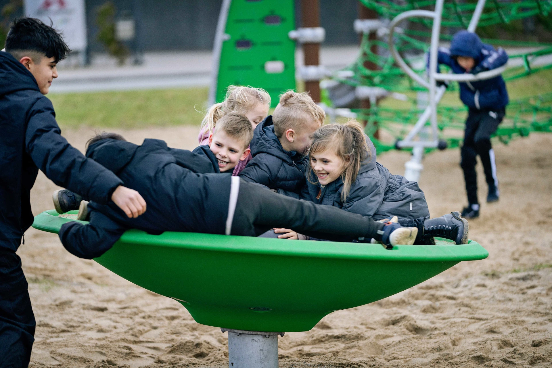Børn leger på en legeplads i en karrusel