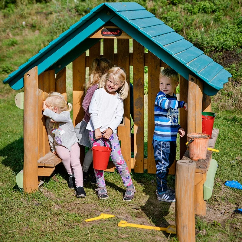 puinen leikkimökki ja leikkimaja leikkipuisto paljon leikkiviä lapsia referenssikuva