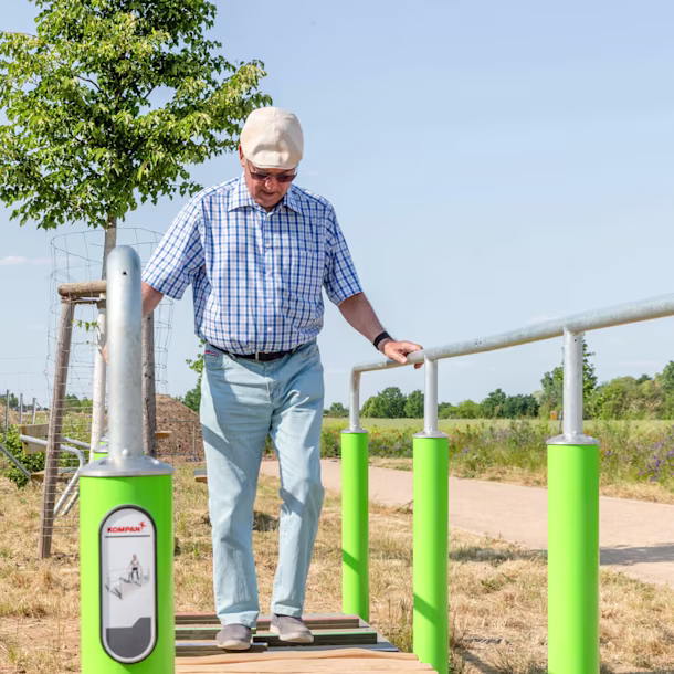 Senioren trainieren an einem Gerät im Freien