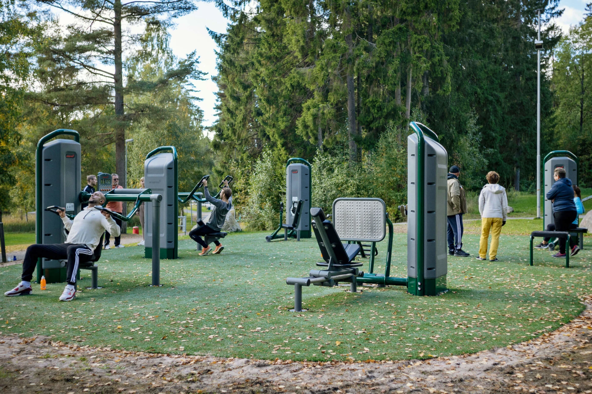 ihmisiä treenaamassa voimaharjoittelulaitteilla ulkona Kypegårdenissa, Ruotsi