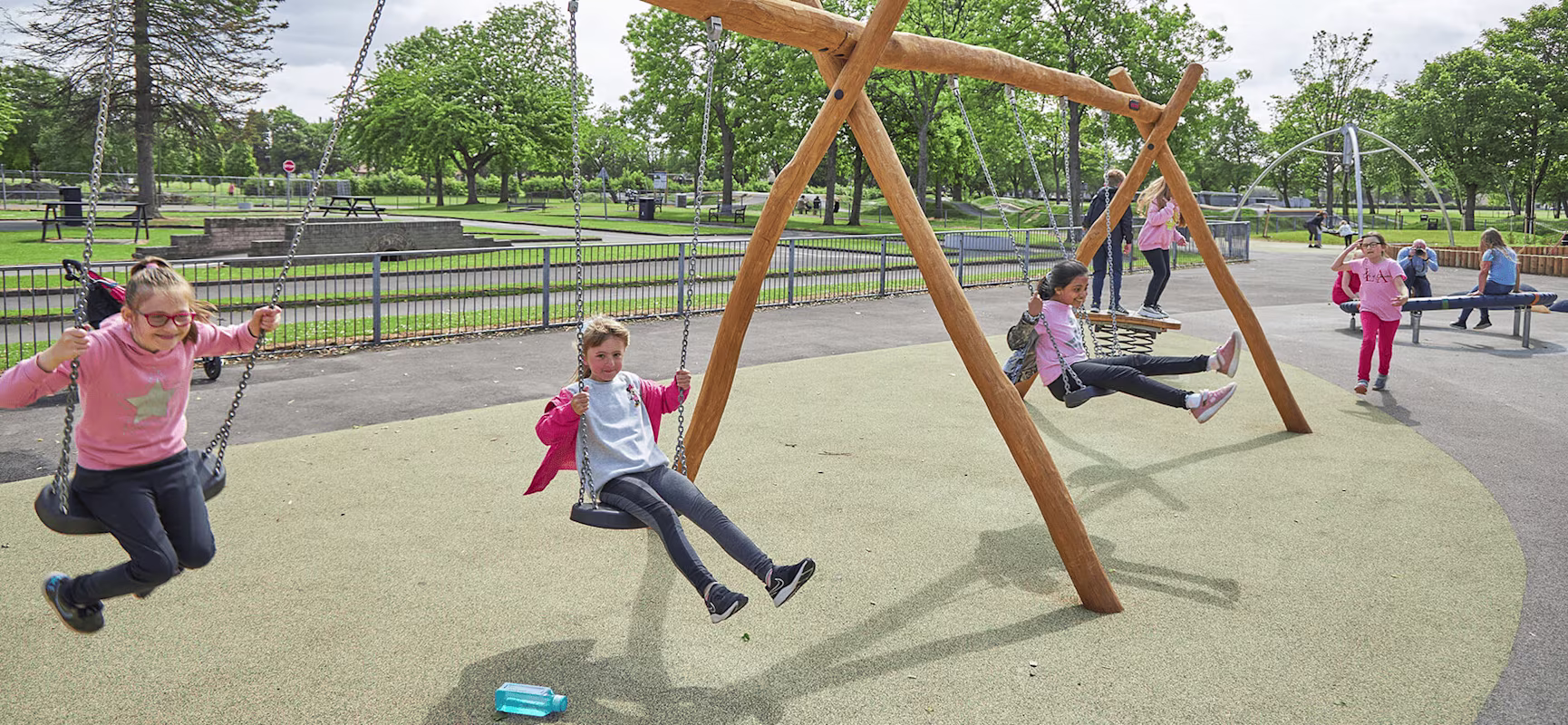 children playing on classic large wooden swings hero image