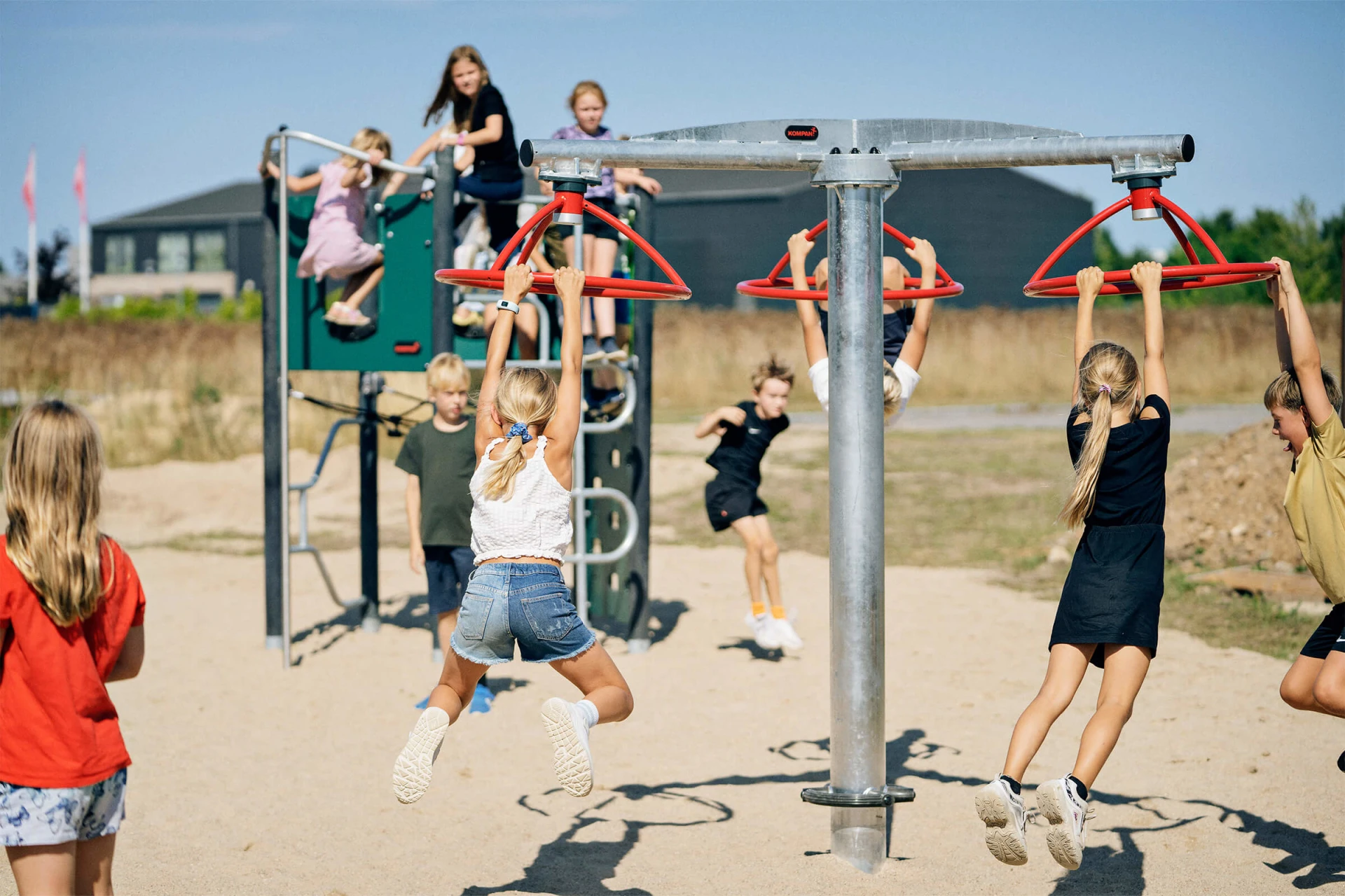 Children spinning on playground equipment in a schoolyard