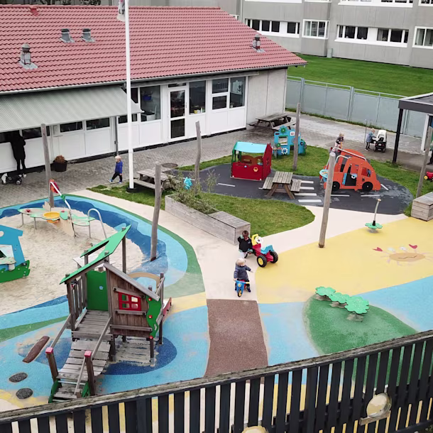 Drone photo of a colourful preschool playground with swings, wooden equipment, a sandpit and more. Offering different types of play is a great way to improve the popularity of your outdoor playground project.