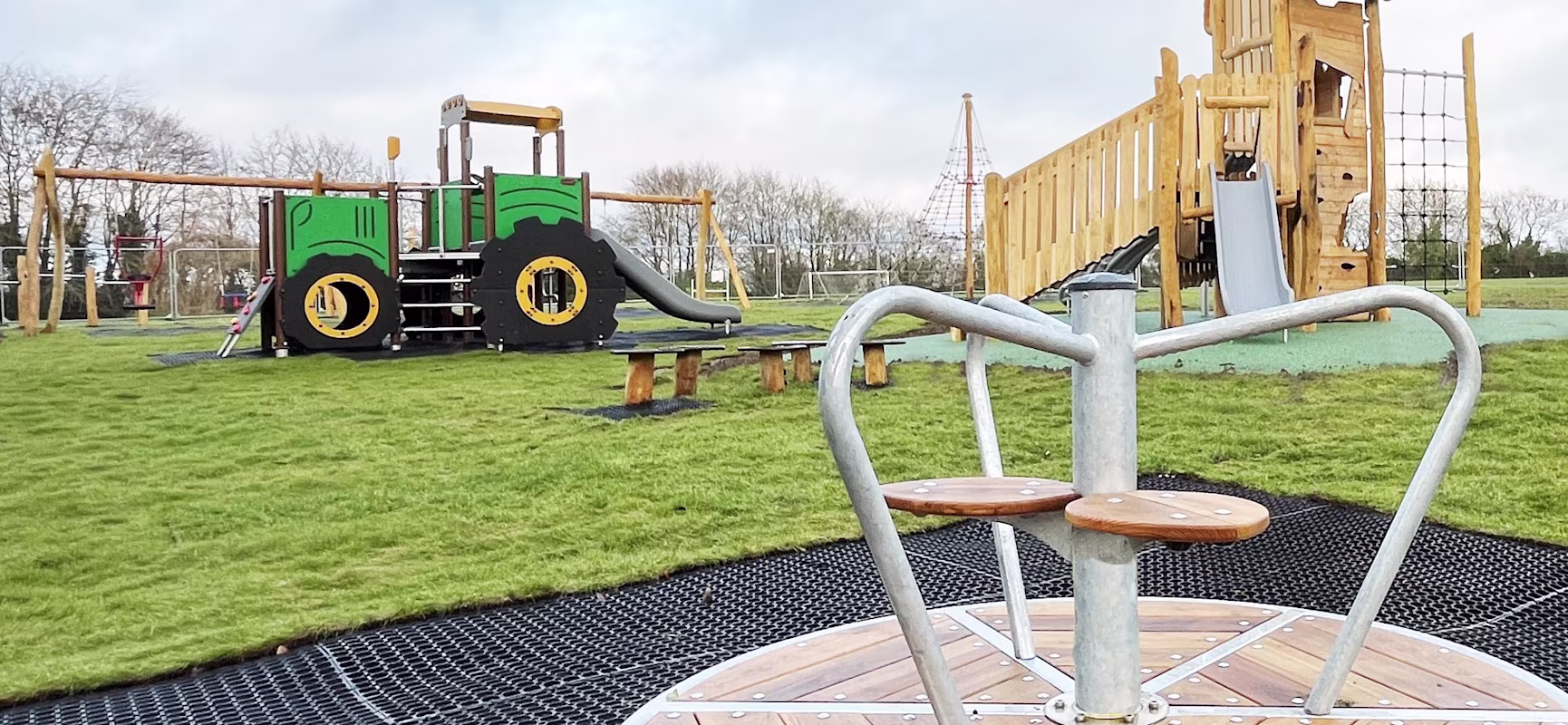 A natural wooden playground with tractor themed play system